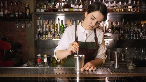 Female Bartender Prepares Drink at a Bar