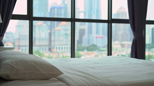 Man Jumps onto Bed in City Apartment