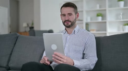 Man Video Calling on Tablet in Living Room