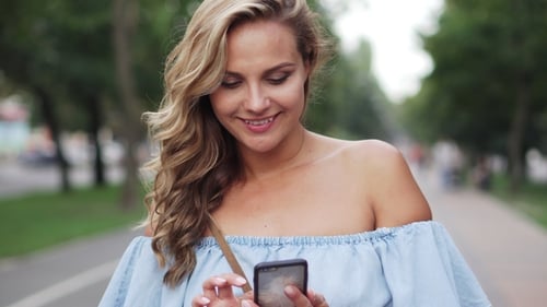 Woman Using Smartphone on Urban Pathway