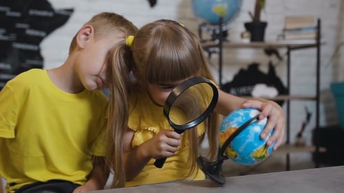 Children Study Globe with Magnifying Glass
