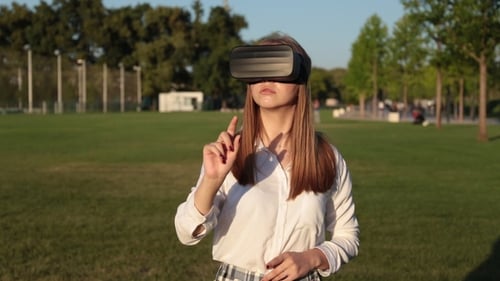 Young Woman in Virtual Reality Glasses in the Park.