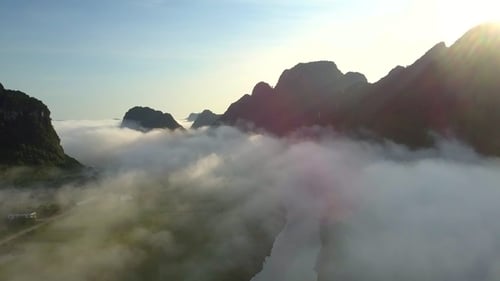 Ruhiger Fluss im nebelbedeckten Tal vor Hügeln