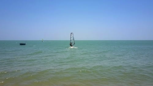 Windsurfer with Transparent Sail Starts Moving From Beach