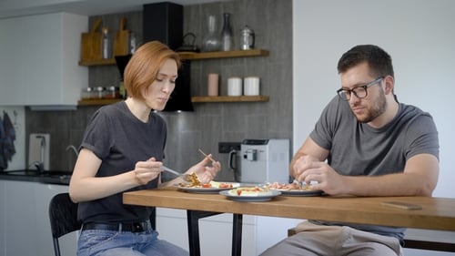 Couple Eating Food at Table in Modern Kitchen