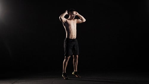 Der Athlet trainiert in einer Turnhalle, liegt auf einem Boden und macht Liegestütze, dann steht er