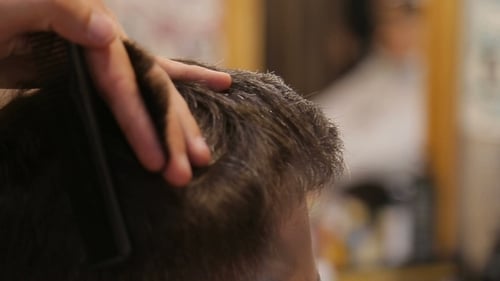 Master Cuts Hair and Beard of Men in the Barbershop, Hairdresser Makes Hairstyle for a Young Man