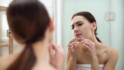 Problem Skin. Woman Crushing Spot On Face And Looking In Mirror