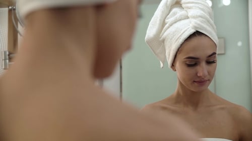Skin Care. Woman Cleaning Face With Lotion At Bathroom