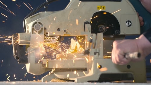 A Man on a Blue Background Separates the Metal Tube with Sparks