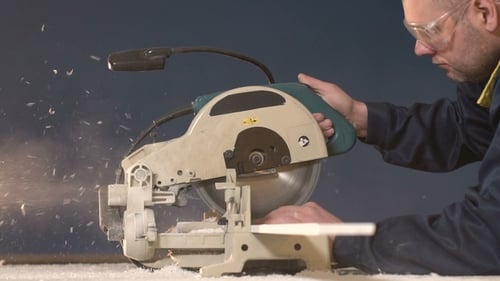 A People on a Blue Background Lowers the Saw and Processes the Tree