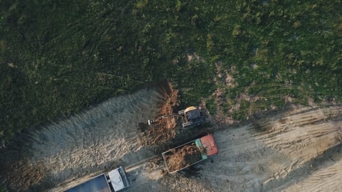 Excavator Loading Soil into Truck, Aerial View