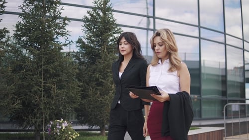 Confident Business Women Walking Down the Street. Business Partners Are Talking on the Go
