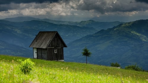 Cloud Movement Over the Old Wooden Little House Against Mountains Background