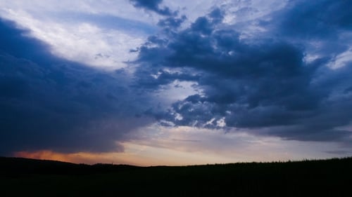 Silhouette of Dark Meadow Against Sunset or Dawn Background