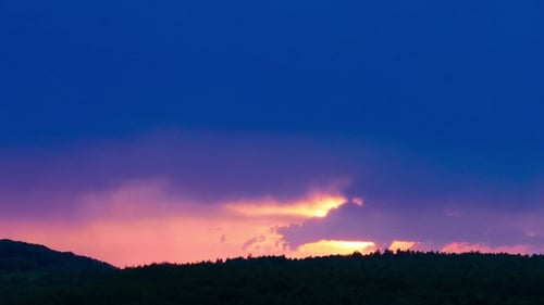 Silhouette of Dark Meadow Against Sunset or Dawn Background