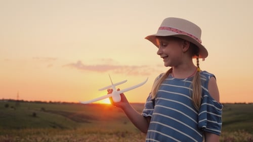 Girl with Toy Airplane Outdoors at Sunset