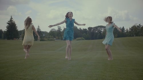 Carefree Women Jumping on Green Grass in Summer