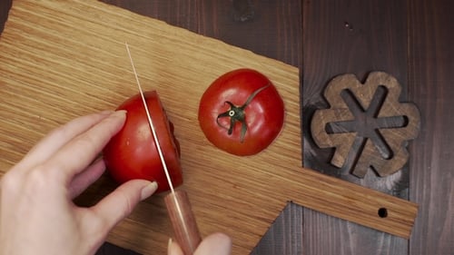 Chef Cuts the Tomato By Sharp Steel Knife on the Wooden Board, Cooking the Salad