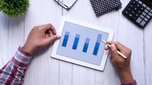 Man's Hand Working on Digital Tablet at Office Desk, Using Self Created Chart