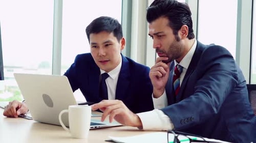 Zwei Geschäftsleute sprechen im Büro über Projektstrategie