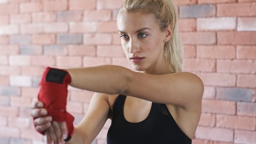 Woman Stretching Wrists With Boxing Wraps