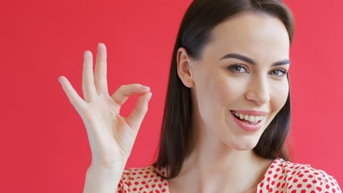 Woman Smiling with Okay Hand Gesture Close Up