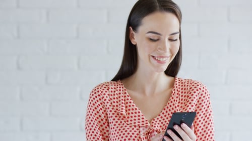 Smiling Young Woman Using Smartphone Indoors