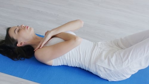 Woman Doing Crunches on Yoga Mat Indoors