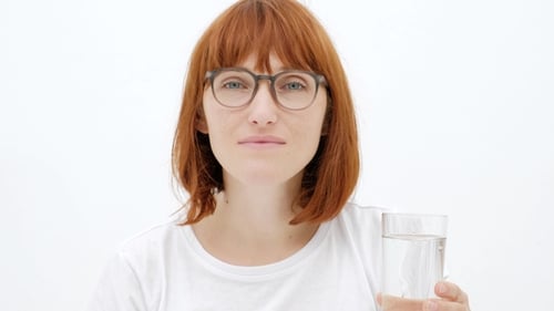 Woman Takes a Pill with Water, Close Up