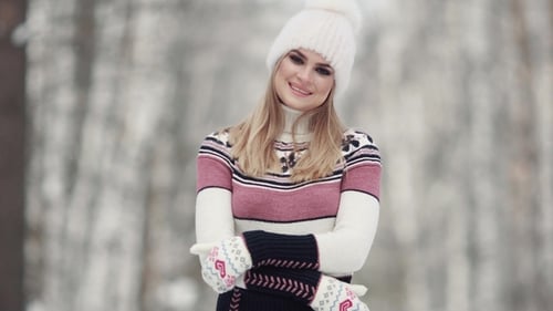 Winter Forest. Portrait of a Young Woman Wearing a Mitten Sweater and a Winter Hat