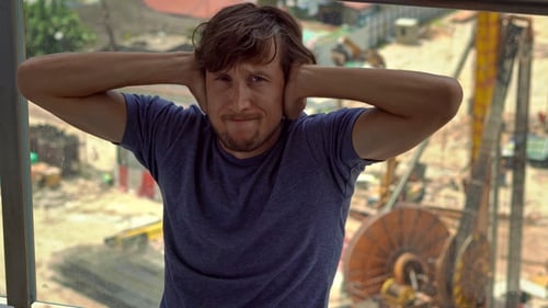 Man Covers Ears Near Construction Site