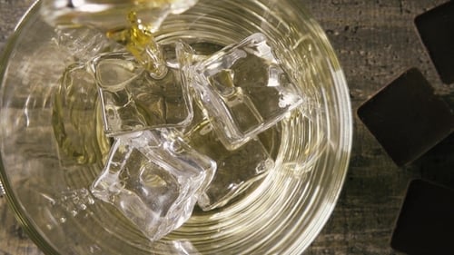 in the Glass with Artificial Ice Pouring Whisky Top View