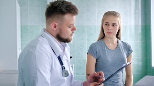 Doctor Consulting with Patient in Hospital Office