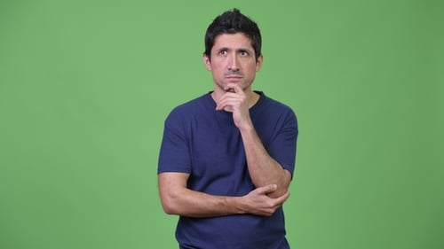 Hispanic Man Thinking Against Green Background