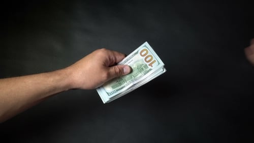 Hands Exchanging Stack of Money Close Up