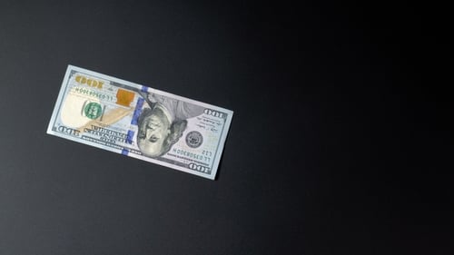 Green Dollars or US Dollars Are Slowly Spinning on a Black Background