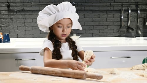 Little Girl in Chef Hat Playing with Dough and Rolling Pin Laughing Having Fun
