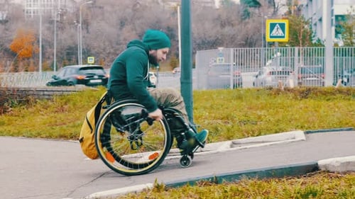 Disabled Man in Wheelchair Makes Attempt To Steer His Wheelchair Over a Ramp on the Street