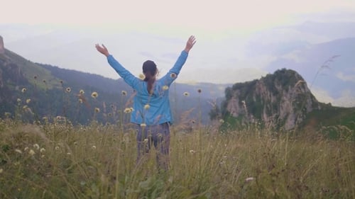 Happy Traveling Woman with Raised Hands Enjoying Beautiful Mountain Landscape