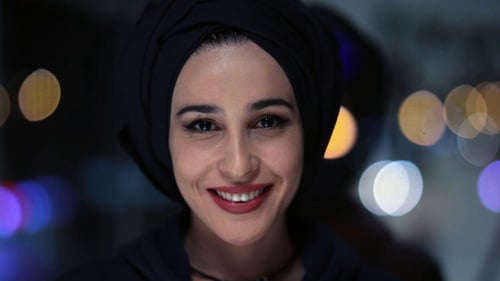 Smiling Woman in Head Covering in the City at Night