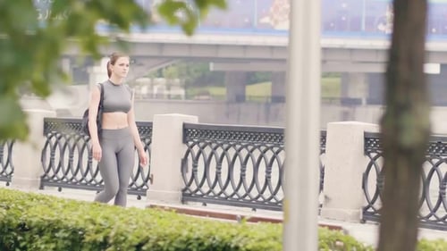 Young Woman in Sportswear and Fitness Bag Walking on Summer Park