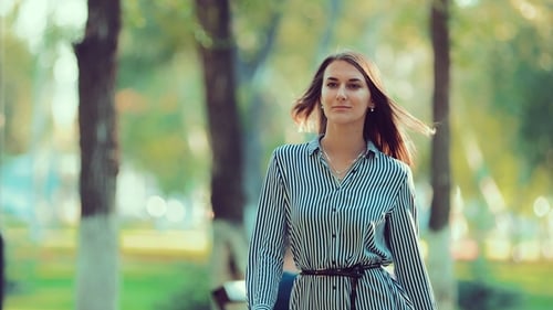 Stylish Woman Walks in Green Urban Park