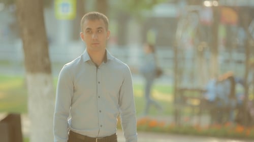 Young Guy Is Waiting for Someone To Wait in the Summer or in the Spring Season in the Park