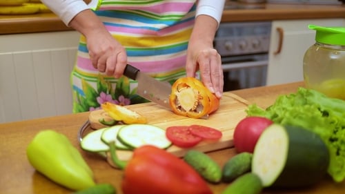 Woman Slicing Vegetables in a Kitchen