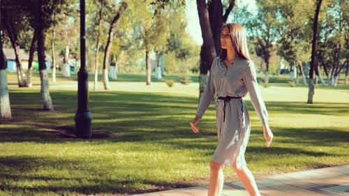Young Beautiful Girl Walks in the Park at a Rapid Pace