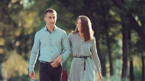 Young Couple Walking Along the City Park Together, Go To the Camera