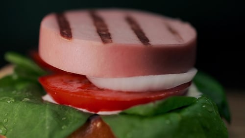 Close-up of Hamburger Preparation with Grilled Sausage