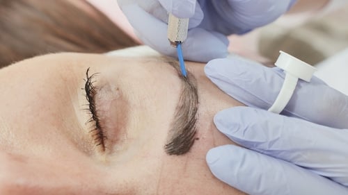 Permanent Makeup. Permanent Tattooing of Eyebrows. Cosmetologist Applying Permanent Make Up on