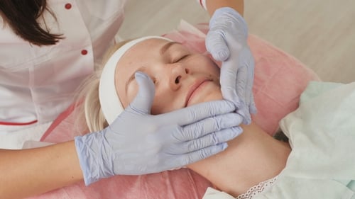 Woman Receiving a Relaxing Facial Treatment at Spa